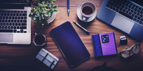 Desk with phone, pencil, laptops and other accessories